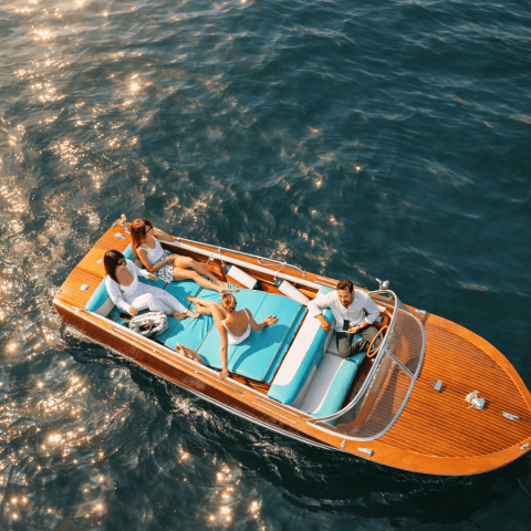 Top view of four people relaxing on a small boat in sparkling water.