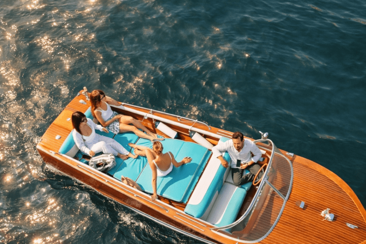 Top view of four people relaxing on a small boat in sparkling water.